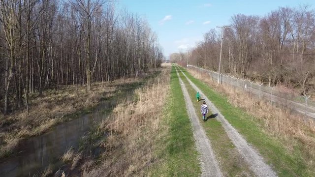 Two Kids Walking On The Trail At The Park In Monroe, Michigan On A Sunny Day - Drone Shot