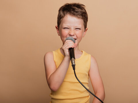 Preteen boy singing in microphone in studio