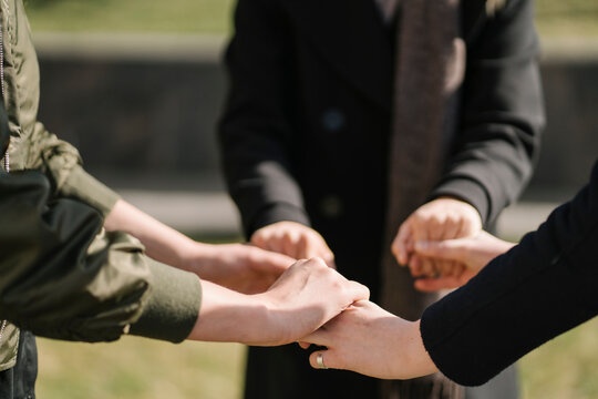 Close-up of three women holding their hands