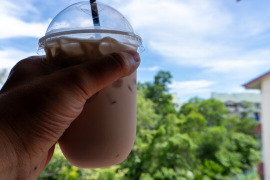 horizantal shot of a hand holding a coffee 