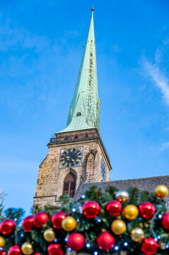 A festive scene with Christmas decorations in the foreground and the Cathedral of St. Bartholomew in Plzen, Czech Republic, in the background. A charming mix of tradition and holiday spirit