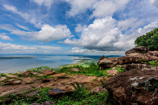 Natural background of clear sky, amidst the blue sky at the viewpoint, there are trees, sun, water retention dam, a nature stop for tourists.