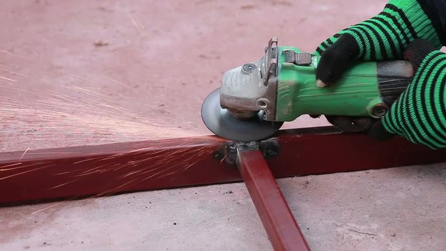 Worker using industrial grinder scrub steel