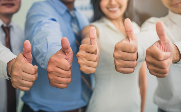 Cheerful business group giving thumbs up. Group of happy multiracial businesspeople gesturing thumb up sign.