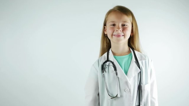 A girl in a doctor's uniform smiles and shows a syringe.