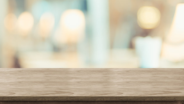 Empty rustic wood table and blurred soft light table in restaurant with bokeh background. product display template.Business presentation.