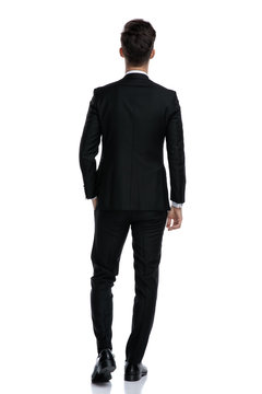 back view of elegant man in tuxedo walking