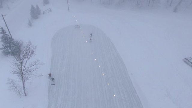 Winter in Northern Michigan in Charlevoix Playing Ice Hockey Pond rink 4K drone shots over forest and open woods in winter snow covered scene logo here