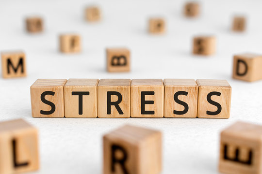 Stress - word from wooden blocks with letters, great worry caused by a difficult situation stress concept, random letters around white background