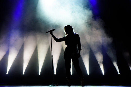 Vocalist singing to microphone. Singer in silhouette