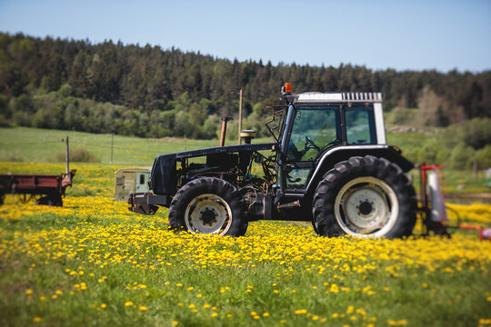 Tractor with a disc harrow system on the cultivated farm field, process of harrowing and preparing the soil, tractor seeding crops at field, agriculture concept, harrow machine at work