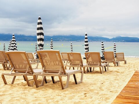 Beach chairs with closed umbrellas on a cloudy dah