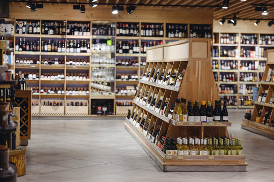 Empty fine modern wine aisle rows in alcohol beverage department at supermarket store grocery shop inside hypermarket. Purchasing food gastronomy, urban lifestyle, consumerism and marketing concept.