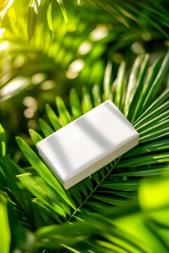 White blank soap package on green tropical leaves, perfect for mockup