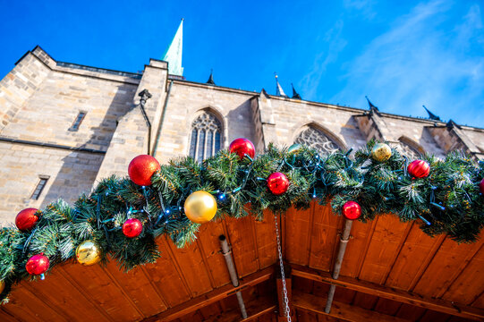 A festive scene with Christmas decorations in the foreground and the Cathedral of St. Bartholomew in Plzen, Czech Republic, in the background. A charming mix of tradition and holiday spirit