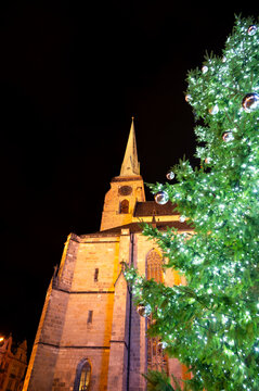 A festive scene with Christmas decorations in the foreground and the Cathedral of St. Bartholomew in Plzen, Czech Republic, in the background. A charming mix of tradition and holiday spirit