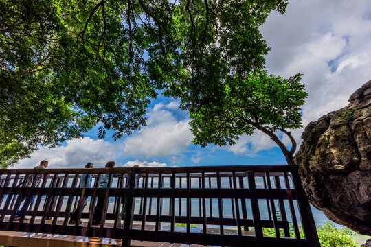 Natural background of clear sky, amidst the blue sky at the viewpoint, there are trees, sun, water retention dam, a nature stop for tourists.