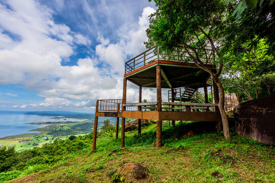 Natural background of clear sky, amidst the blue sky at the viewpoint, there are trees, sun, water retention dam, a nature stop for tourists.