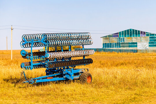 a trailed harrow stands in a field. harrowing the soil. harrow trailer for tractor