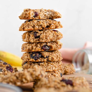 Side view of banana breakfast oat cookies stacked high on top of each other.