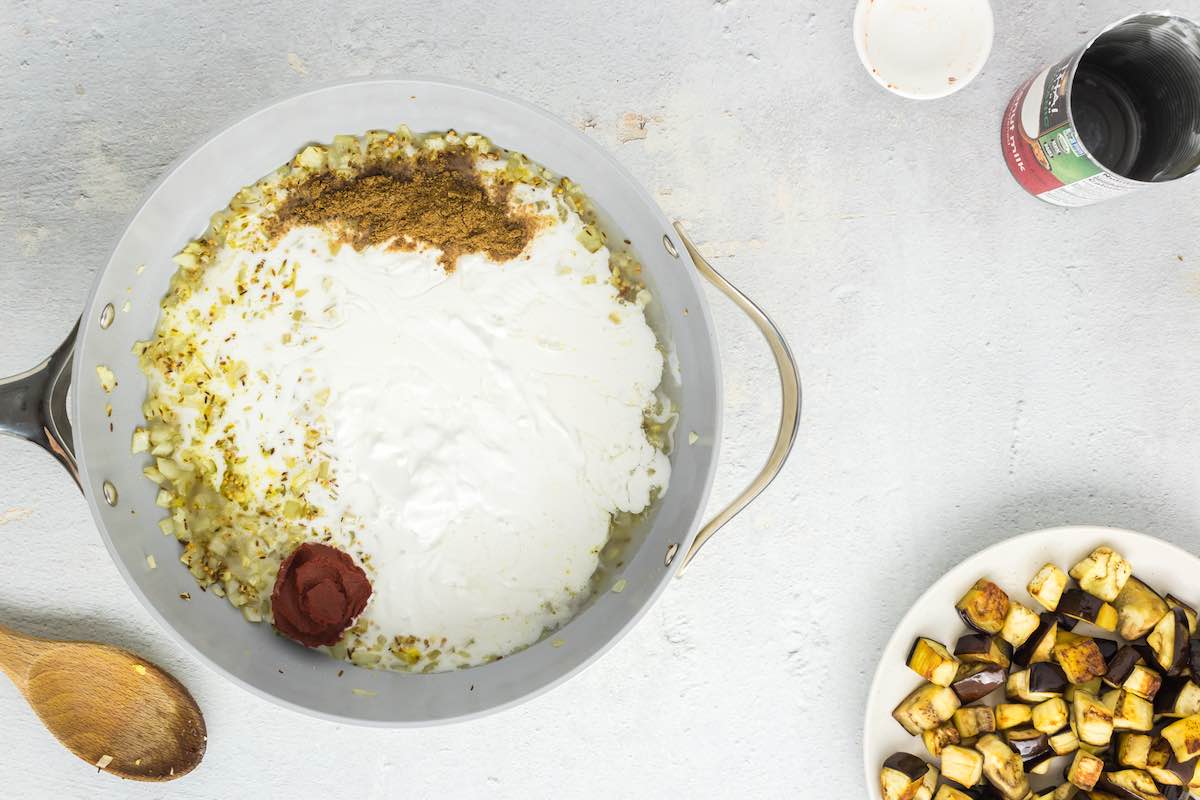 coconut milk, spices, and aromatics in a skillet.