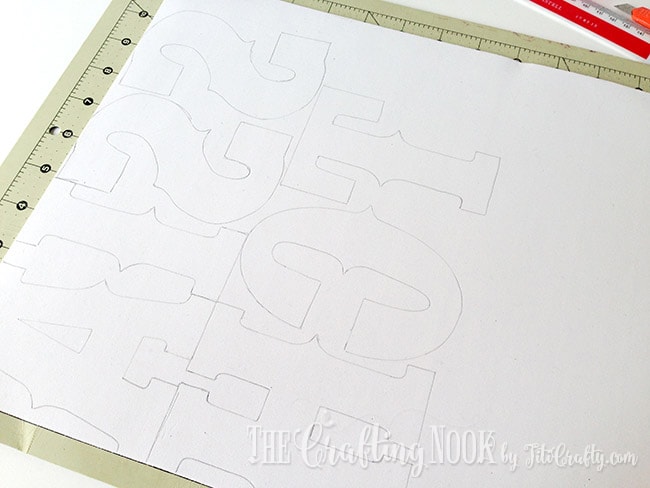 sheet of paper with letters drawn on cutting mat