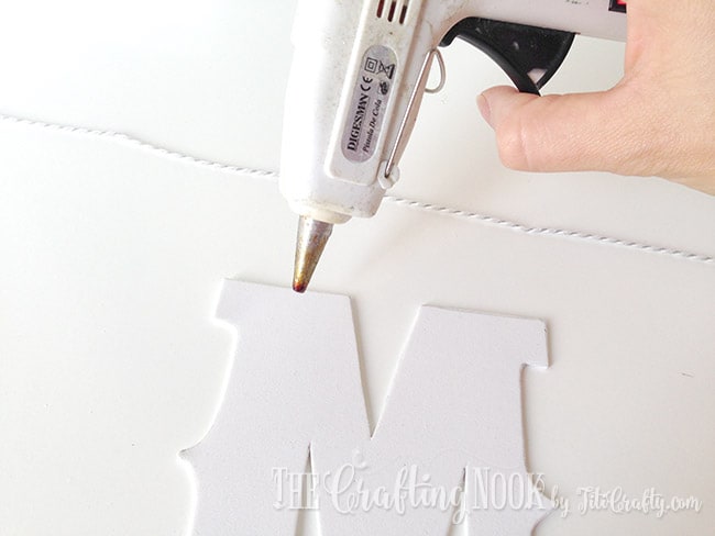 placing hot glue over the top of the letter