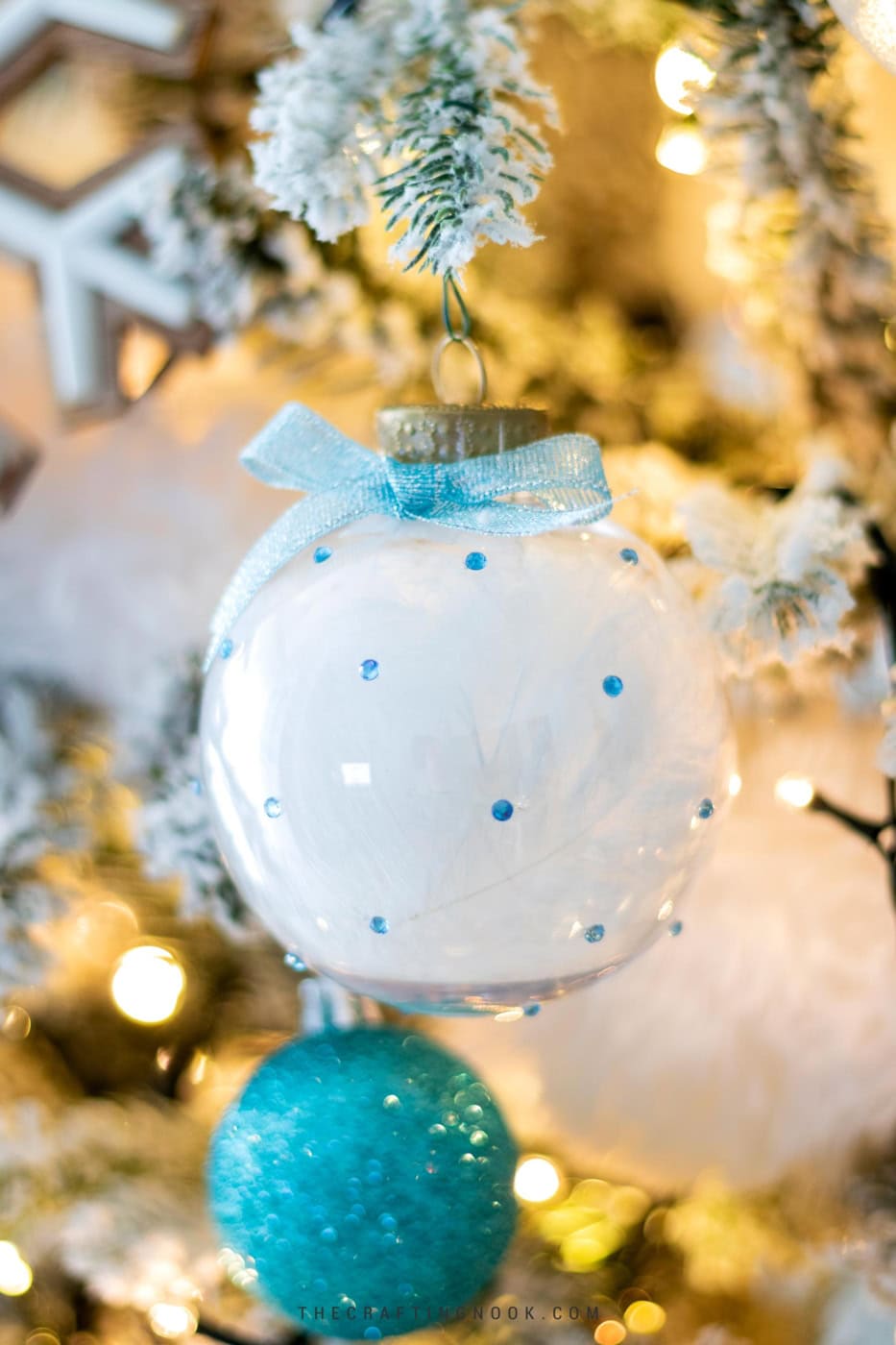 DIY Rhinestone Christmas Ornaments Filled with Feathers hanging on the tree. Cover Image