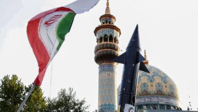 Iranians lift up a flag and the mock-up of a missile during a celebration following Iran's missiles and drones attack on Israel, on April 15 2024, at Palestine square in central Tehran