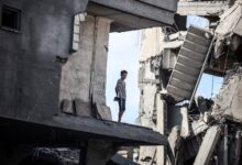 A young Palestinian boy stands near a building destroyed by an Israeli airstrike in the Nuseirat refugee camp in central Gaza Strip on August 23, 2024