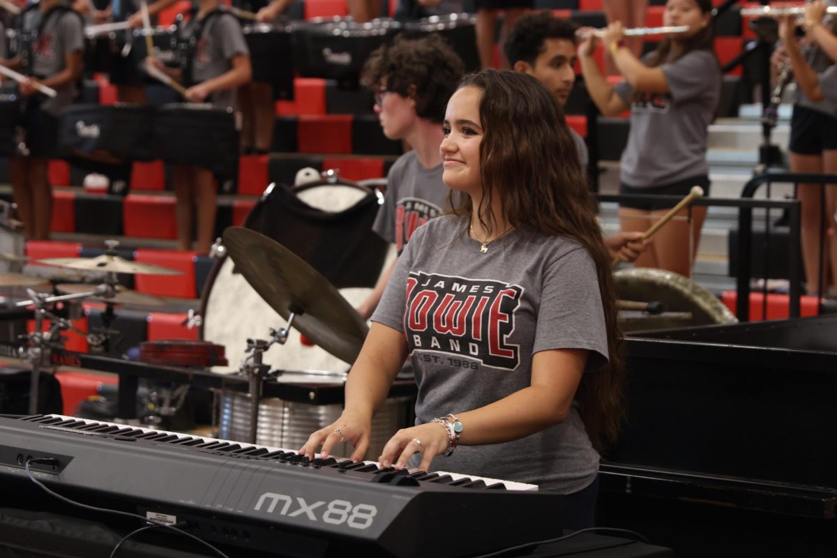 CREATING SCHOOL SPIRIT: Besa Carney enthusiastically plays piano for the students and families attending the Bulldogs and Hotdogs pep rally. Carney is the only piano player that performs with the Bowie band.