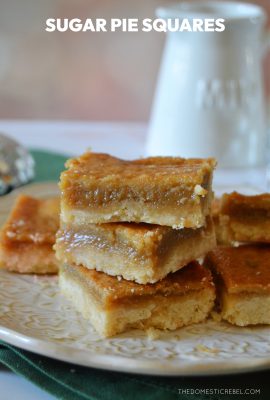 sugar pie squares stacked on a white plate and a green towel