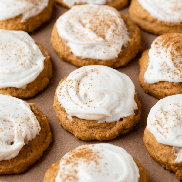 rows of pumpkin cookies with cream cheese frosting