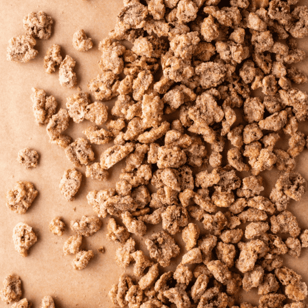 close up of candied walnuts spread out on brown paper