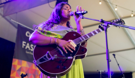 Amanda Lowe performs on Fasken Stage with purple light shining on them.