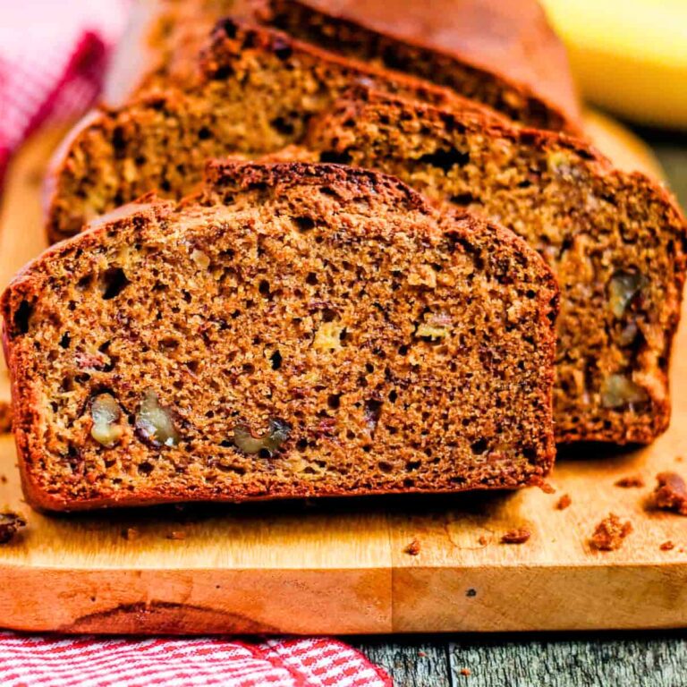 slices of banana bread with sour cream on a cutting board.