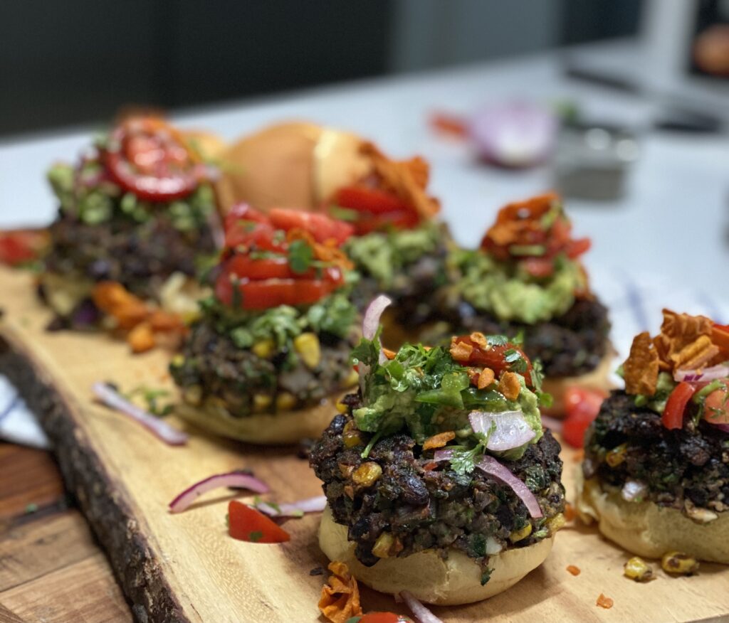 A wooden cutting board topped with mushrooms covered in toppings.