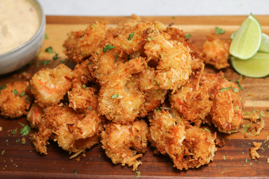 A wooden cutting board topped with lots of fried food.