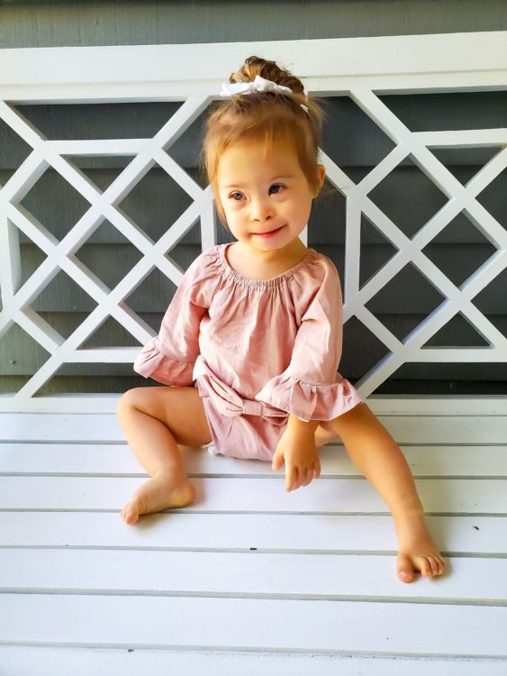 Ivy sitting on a white decking with decorative railing.