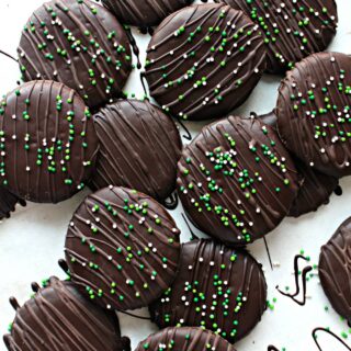 Cookies coated in chocolate topped with chocolate drizzle and sprinkles.