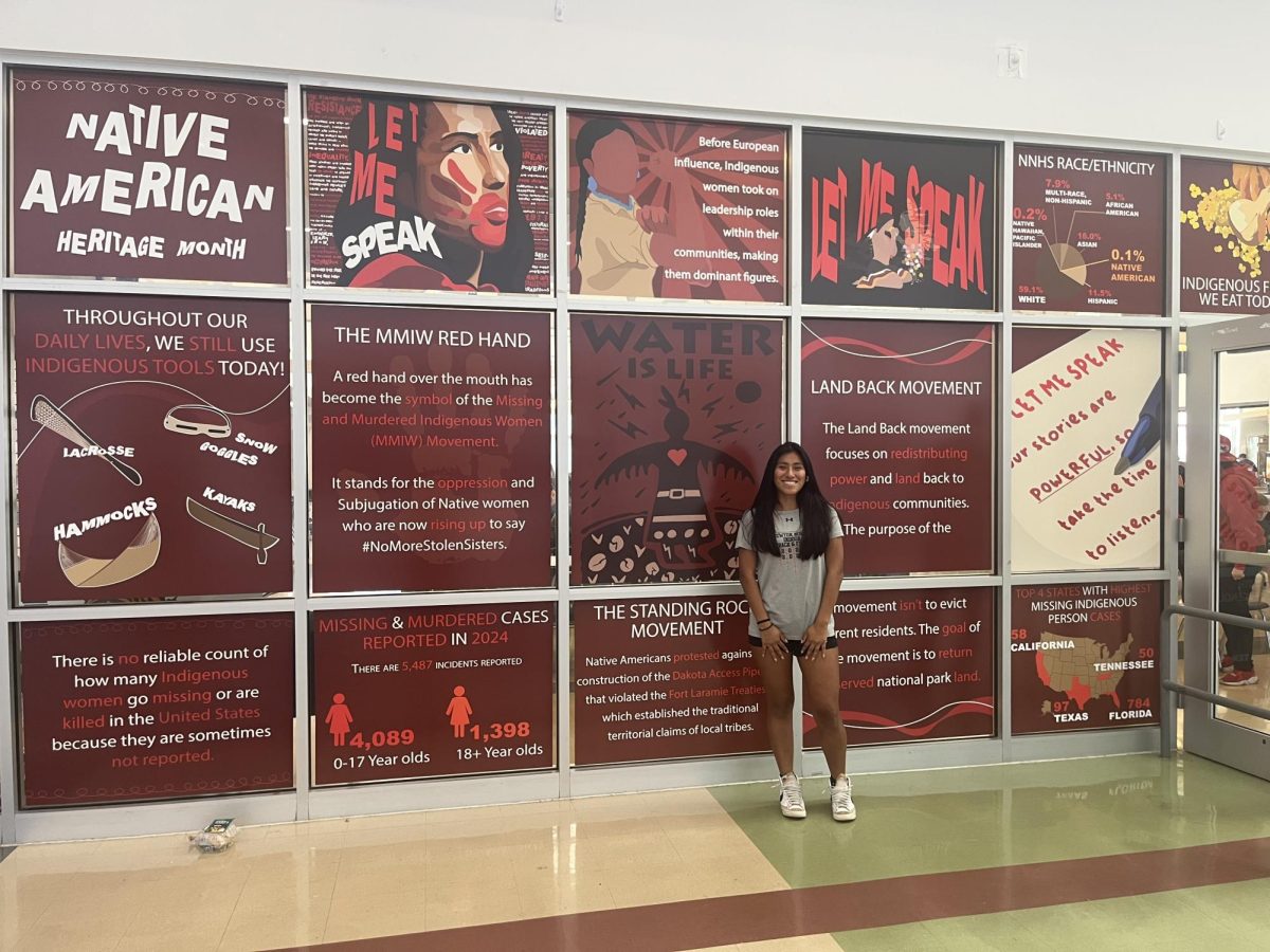 Senior Carolina Darcy poses with the window display she designed.