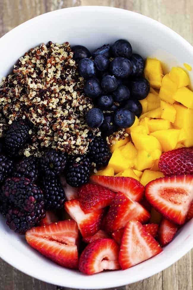 honey lime quinoa salad ingredients in a white bowl.