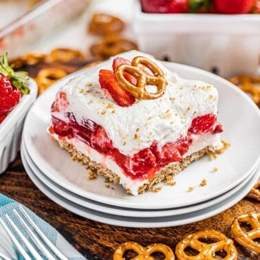 A slice of strawberry pretzel salad on a stack of plates.