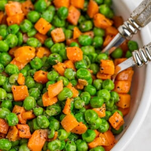 Overhead view of peas and carrots in a bowl.;