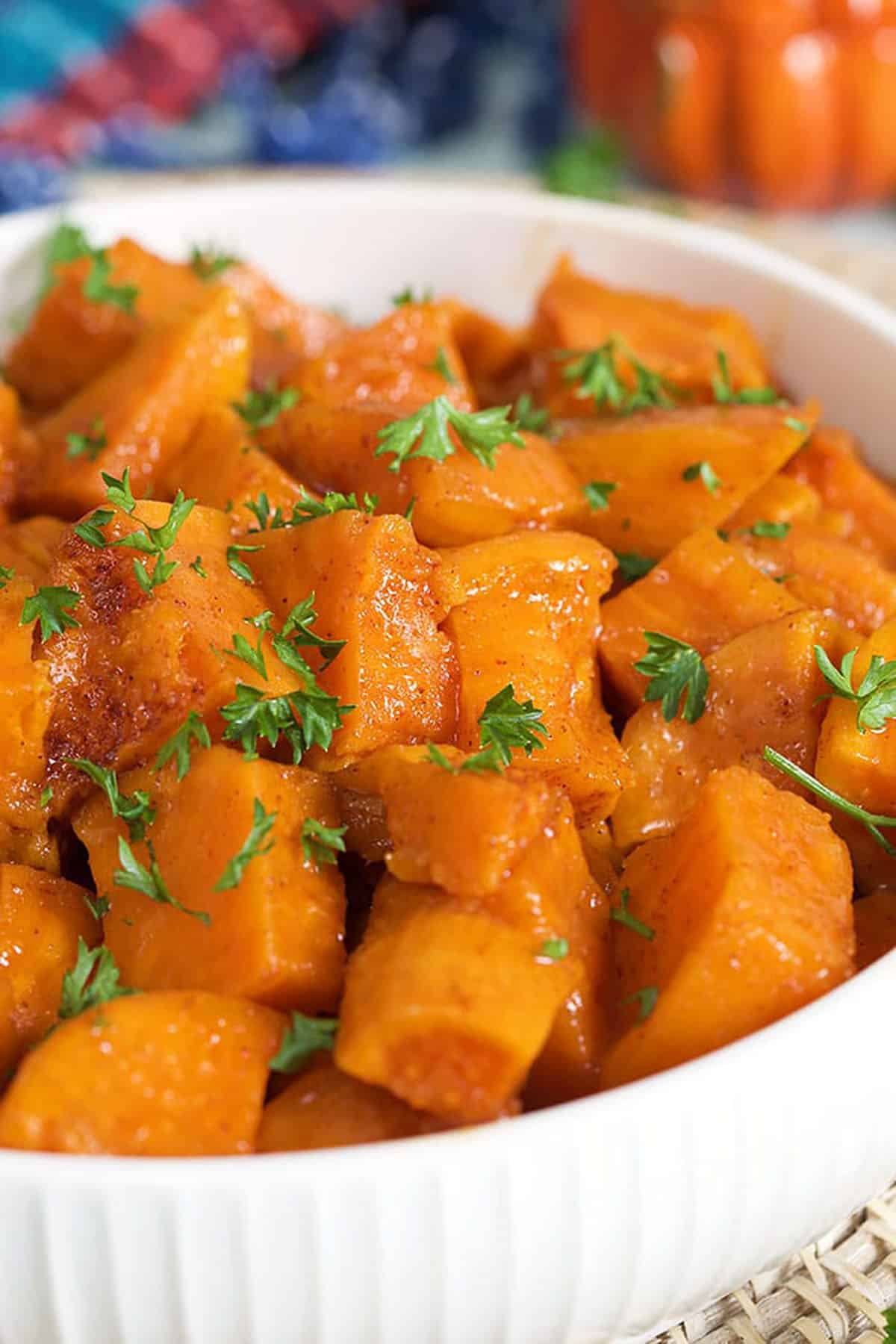 Candied yams close up in a white bowl.