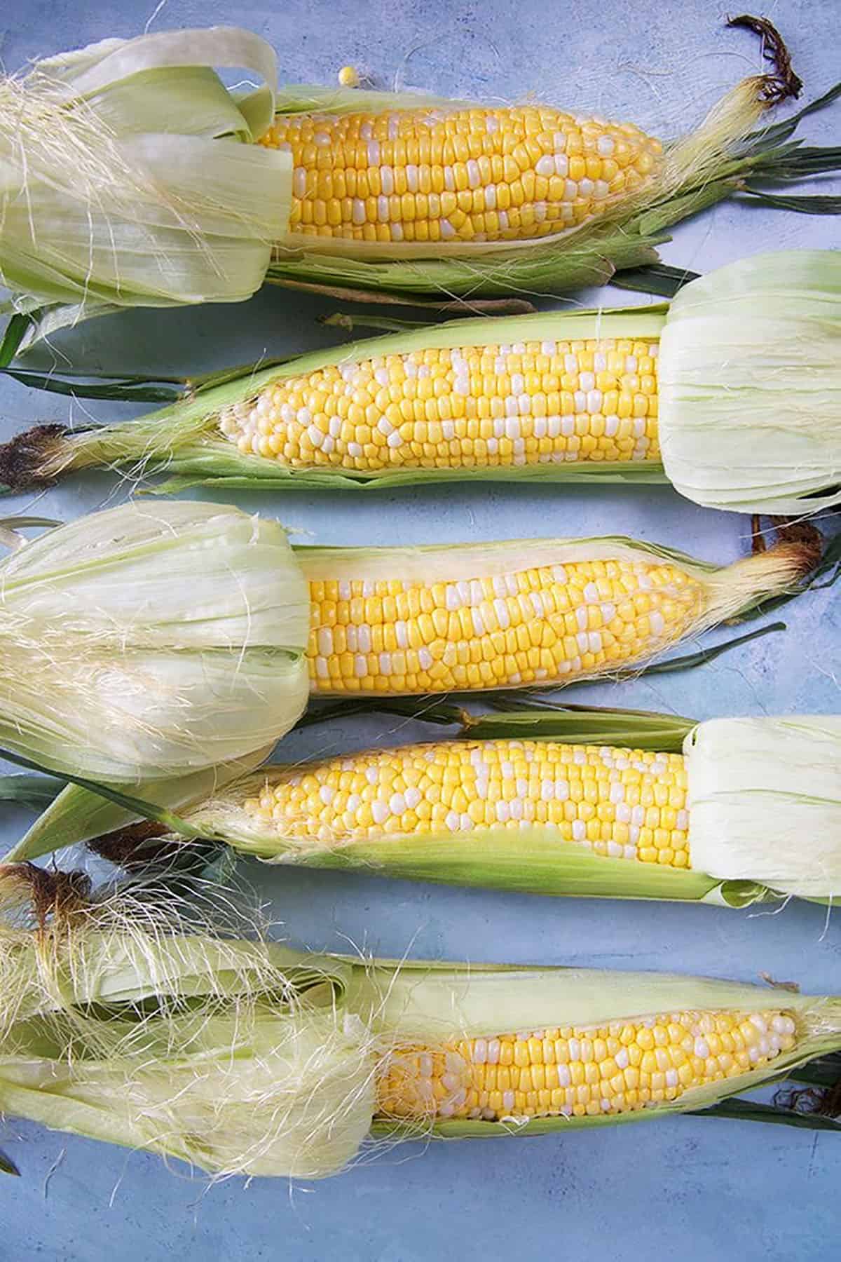  corn on the cob in the husks.