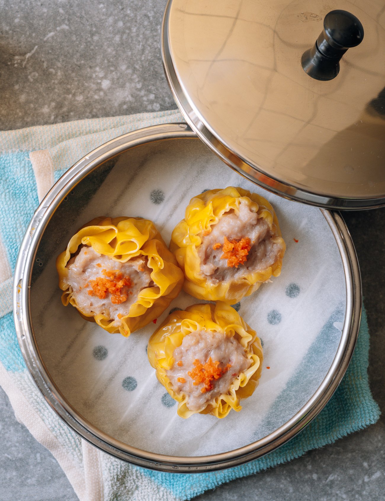 three steamed siu mai in metal dim sum basket