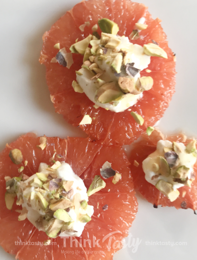 Grapefruit slices topped with yogurt and pistachios