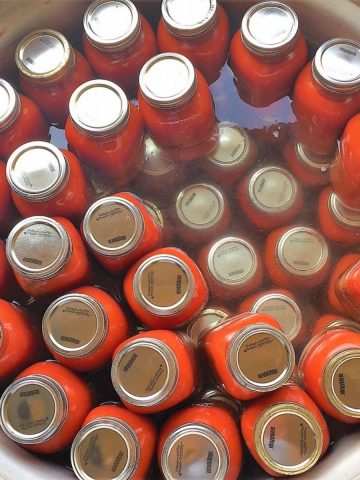 Large pot with jars of tomato sauce.