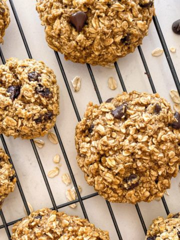 Oatmeal cookies with chocolate chips on cooling rack.